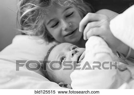 Stock Photography - Caucasian girl playing with baby brother. Fotosearch