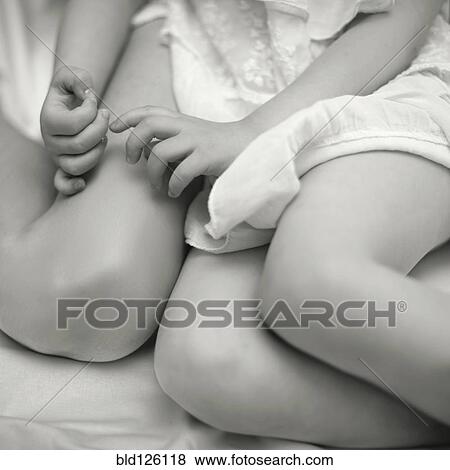 Stock Photo - Caucasian girl sitting on bed. Fotosearch