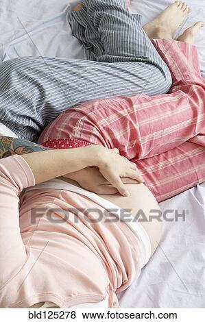 Stock Photo - Caucasian lesbian couple holding pregnant belly. Fotosearch