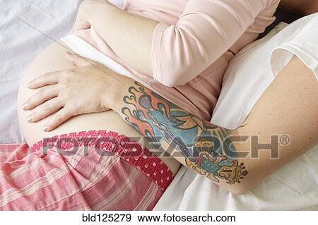 Caucasian lesbian couple holding pregnant belly View Large Photo Image Stock Photo - Caucasian lesbian couple holding pregnant belly. Fotosearch