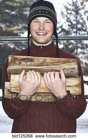 Caucasian man carrying firewood in snow View Large Photo Image Stock Photo - Caucasian man carrying firewood in snow. Fotosearch