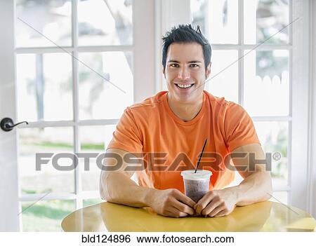 Caucasian man drinking smoothie in kitchen View Large Photo Image Stock Photograph - Caucasian man drinking smoothie in kitchen. Fotosearch