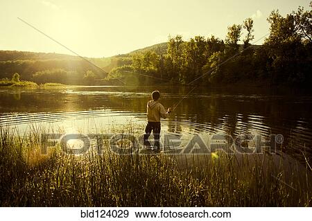 Caucasian man fishing in still lake View Large Photo Image Stock Photo - Caucasian man fishing in still lake. Fotosearch