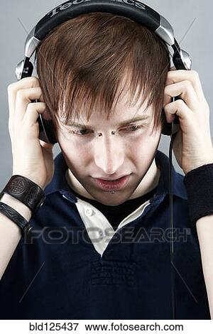 Stock Photo - Caucasian man listening to headphones. Fotosearch