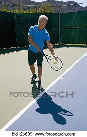 Caucasian man playing tennis on court View Large Photo Image Stock Photo - Caucasian man playing tennis on court. Fotosearch
