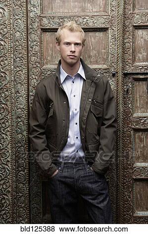 Caucasian man standing at ornate door View Large Photo Image Stock Photo - Caucasian man standing at ornate door. Fotosearch