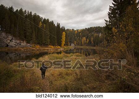 Caucasian man walking in rural landscape View Large Photo Image Stock Image - Caucasian man walking in rural landscape. Fotosearch