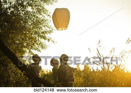 Caucasian men launching floating lantern outdoors View Large Photo Image Stock Photo - Caucasian men launching floating lantern outdoors. Fotosearch