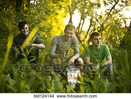 Picture - Caucasian men sitting in woods. Fotosearch