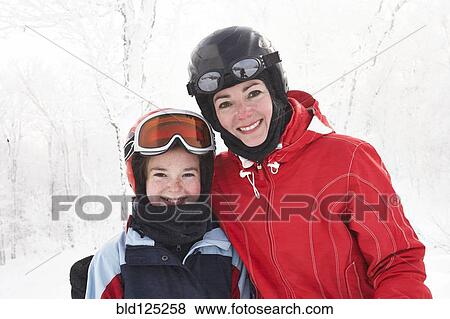 Stock Photo - Caucasian mother and daughter smiling in snow. Fotosearch