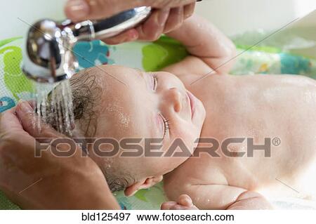 Stock Photo - Caucasian mother giving baby boy a bath. Fotosearch