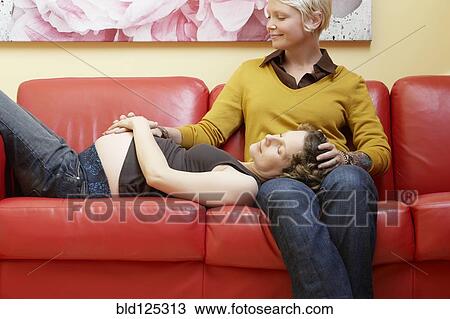Caucasian pregnant lesbian couple relaxing on sofa View Large Photo Image Stock Image - Caucasian pregnant lesbian couple relaxing on sofa. Fotosearch