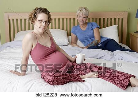 Caucasian pregnant lesbian couple relaxing on bed View Large Photo Image Stock Photo - Caucasian pregnant lesbian couple relaxing on bed. Fotosearch