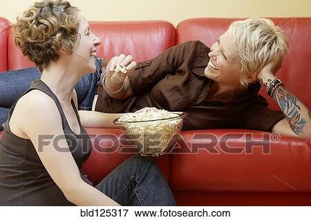 Caucasian pregnant lesbian couple eating popcorn View Large Photo Image Stock Photo - Caucasian pregnant lesbian couple eating popcorn. Fotosearch
