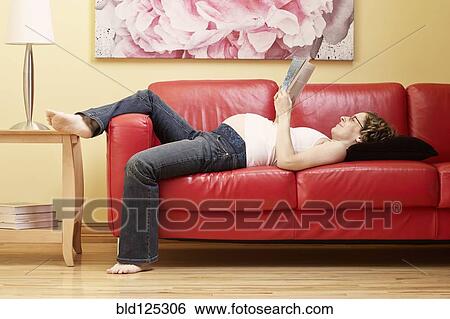 Caucasian pregnant woman reading on sofa View Large Photo Image Stock Photograph - Caucasian pregnant woman reading on sofa. Fotosearch