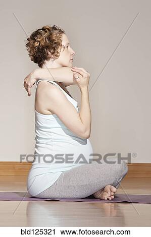 Caucasian pregnant woman stretching on yoga mat View Large Photo Image Stock Image - Caucasian pregnant woman stretching on yoga mat. Fotosearch