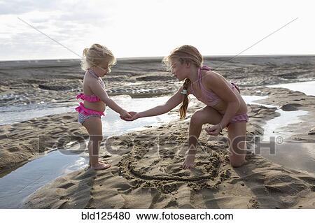 Caucasian sisters playing together on beach View Large Photo Image Stock Image - Caucasian sisters playing together on beach. Fotosearch
