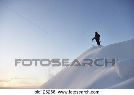 Caucasian skier standing on snowy hilltop View Large Photo Image Stock Photograph - Caucasian skier standing on snowy hilltop. Fotosearch