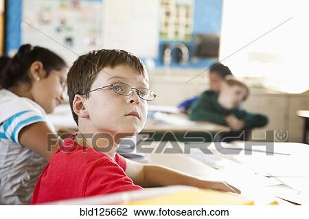 Stock Image - Caucasian student sitting in class. Fotosearch
