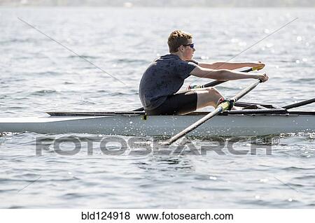 Stock Photo - Caucasian teenage boy rowing on river. Fotosearch