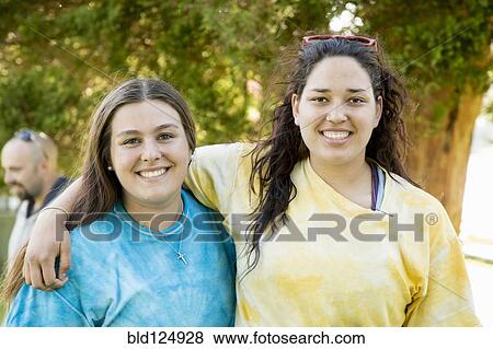 Stock Photo - Caucasian teenage girls hugging outdoors. Fotosearch