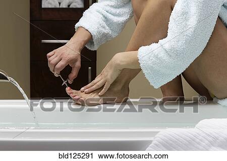 Caucasian woman clipping her toenails at bathtub View Large Photo Image Stock Image - Caucasian woman clipping her toenails at bathtub. Fotosearch