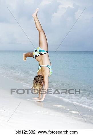Caucasian woman doing cartwheels on beach View Large Photo Image Stock Image - Caucasian woman doing cartwheels on beach. Fotosearch