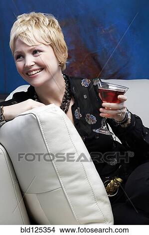 Caucasian woman drinking wine on sofa View Large Photo Image Picture - Caucasian woman drinking wine on sofa. Fotosearch