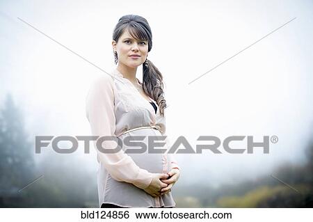 Caucasian woman holding pregnant belly outdoors View Large Photo Image Stock Photograph - Caucasian woman holding pregnant belly outdoors. Fotosearch