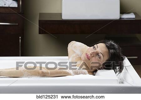Stock Image - Caucasian woman relaxing in bubble bath. Fotosearch