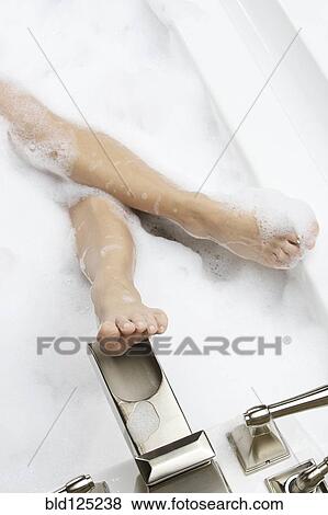 Stock Photo - Caucasian woman relaxing in bubble bath. Fotosearch