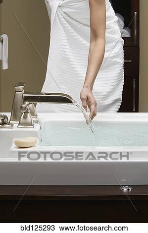 Stock Image - Caucasian woman running bath. Fotosearch