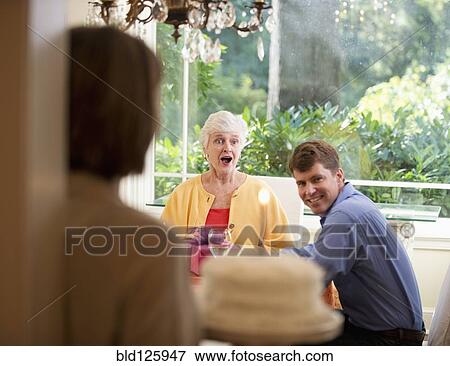 Caucasian woman surprising mother with birthday cake View Large Photo Image Stock Photo - Caucasian woman surprising mother with birthday cake. Fotosearch