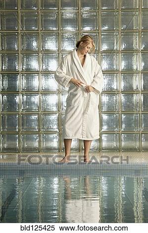 Stock Photography - Caucasian woman wearing bathrobe by pool. Fotosearch