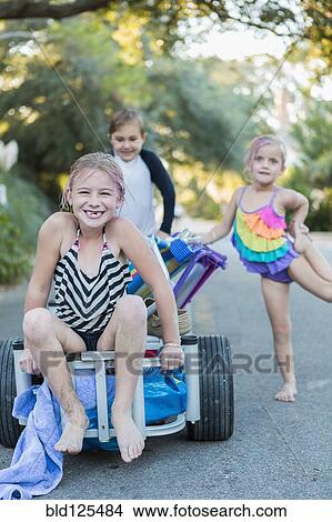 Children in swimsuits pushing cart on rural road View Large Photo Image Picture - Children in swimsuits pushing cart on rural road. Fotosearch