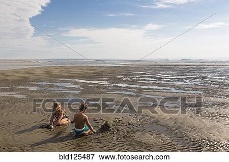 Stock Photo - Children playing on beach. Fotosearch