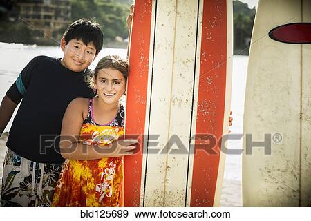Children smiling with surfboards on beach View Large Photo Image Stock Photo - Children smiling with surfboards on beach. Fotosearch