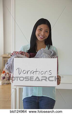 Picture - Chinese woman holding donations box. Fotosearch