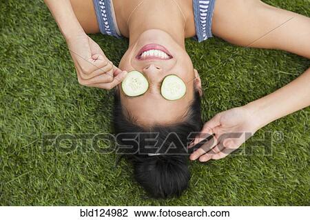Chinese woman with cucumbers on eyes laying in grass View Large Photo Image Stock Image - Chinese woman with cucumbers on eyes laying in grass. Fotosearch