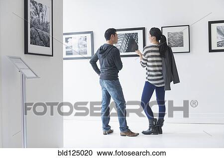 Couple admiring art in gallery View Large Photo Image Stock Image - Couple admiring art in gallery. Fotosearch