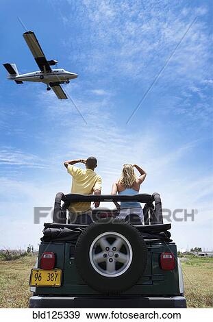 Couple admiring plane from 4x4 View Large Photo Image Stock Photo - Couple admiring plane from 4x4. Fotosearch