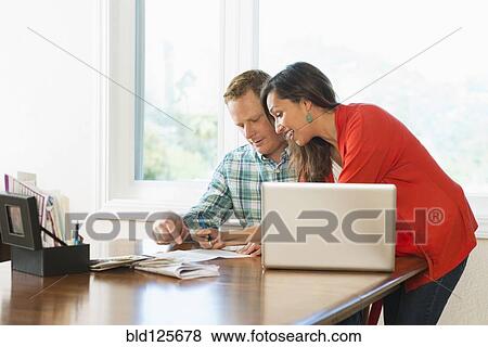 Couple shopping online at table View Large Photo Image Stock Photo - Couple shopping online at table. Fotosearch