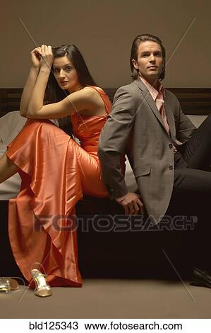 Stock Image - Couple sitting on bed. Fotosearch