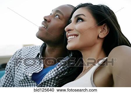 Stock Image - Couple smiling and looking up. Fotosearch