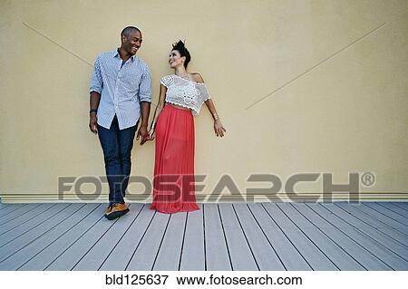 Couple standing against wall outdoors View Large Photo Image Stock Photo - Couple standing against wall outdoors. Fotosearch