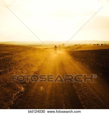 Dirt bikers driving on rural road View Large Photo Image Stock Image - Dirt bikers driving on rural road. Fotosearch