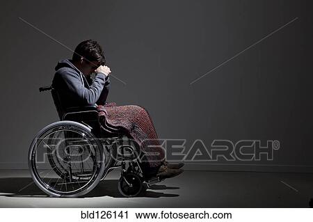 Stock Image - Frustrated Caucasian man in wheelchair. Fotosearch
