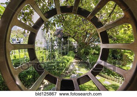 Stock Photo - Garden viewed through metal window. Fotosearch