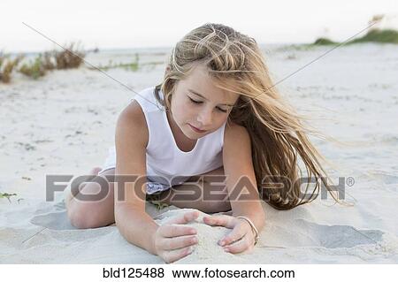Girl playing in sand on beach View Large Photo Image Stock Photo - Girl playing in sand on beach. Fotosearch
