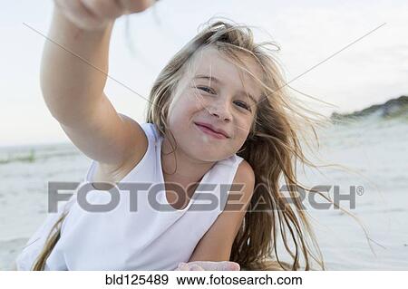 Girl playing in sand on beach View Large Photo Image Stock Photo - Girl playing in sand on beach. Fotosearch